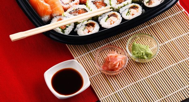 Composition with assorted sushi rolls and bowls of spices - Fotoğraf, Görsel