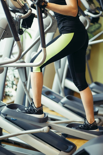 woman exercising on cross trainer machines. - Photo, Image