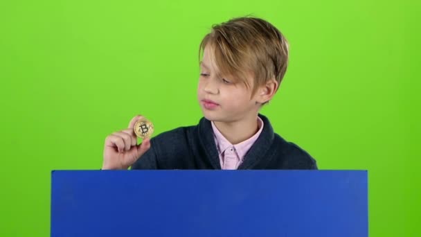 Teenager boy gets up from behind the board with the chip on a green screen. Slow motion - Filmati, video