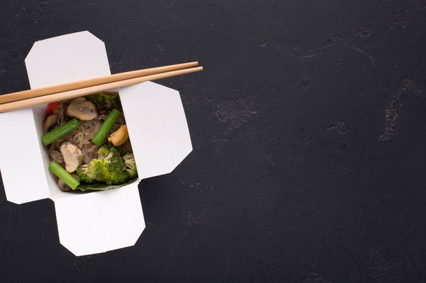 Comida asiática na caixa de entrega no fundo preto
 - Foto, Imagem
