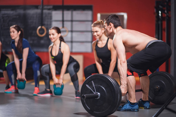 gym group with weight lifting bar workout - Fotó, kép