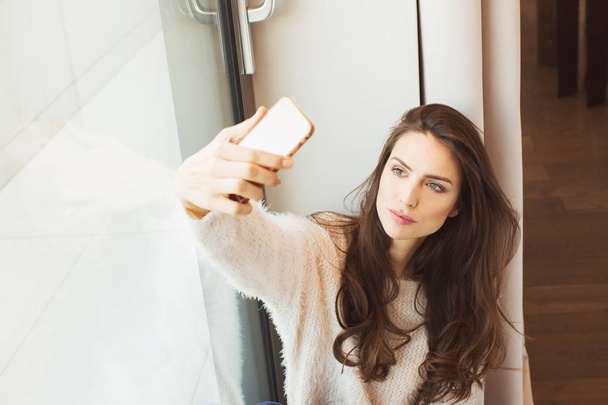 Beautiful Woman With mobile phone by the window - Fotoğraf, Görsel