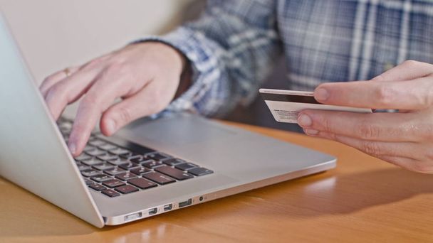Homem digitando número de cartão de crédito no computador portátil
 - Foto, Imagem