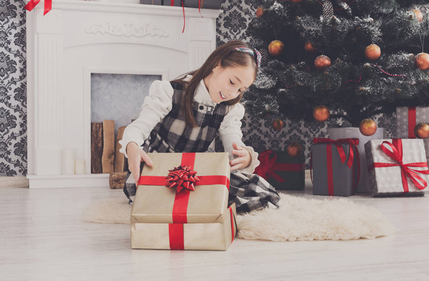Красива дівчина розгортає різдвяні подарунки
 - Фото, зображення