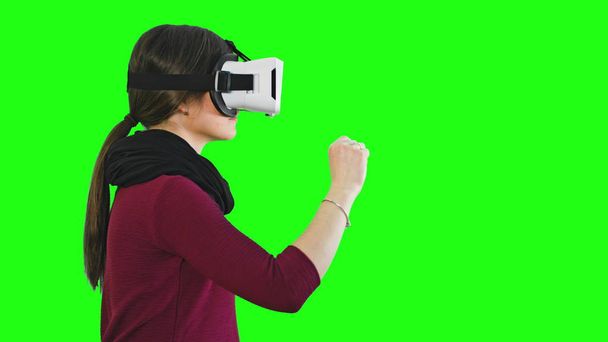 Женщина поворачивает голову с VR гарнитурой
. - Фото, изображение