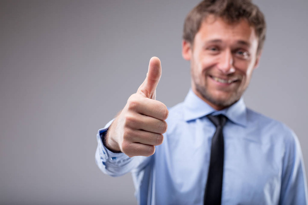 Усміхнений мотивований чоловік піднімає великий палець
 - Фото, зображення