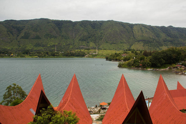 Batak stílusú házak, piros tetővel, Toba-tó, Indonézia. - Fotó, kép