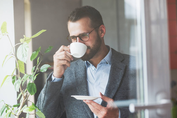 handsome businessman holding morning cup of coffee - Zdjęcie, obraz