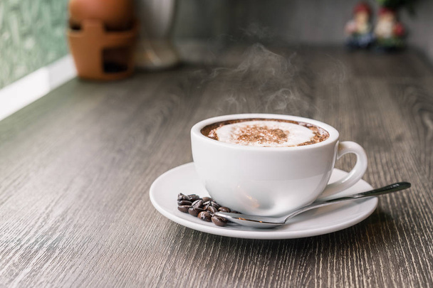 Kahve fincanı ve ahşap masa, sıcak ve iyi koku kahve çekirdekleri - Fotoğraf, Görsel