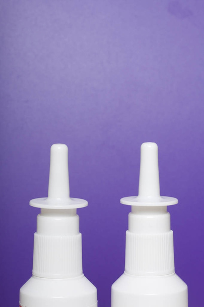 Nasal spray stand on the surface. On a lilac background. - Фото, изображение