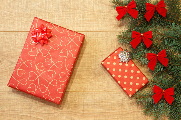 Neujahrs- / Weihnachtsgeschenke im Paket, Baum mit roten Schleifen auf der Holzuntergrund-Vorlage - Foto, Bild