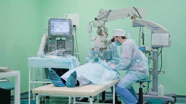 Cirurgiões de Oftalmologia na Intervenção
 - Foto, Imagem