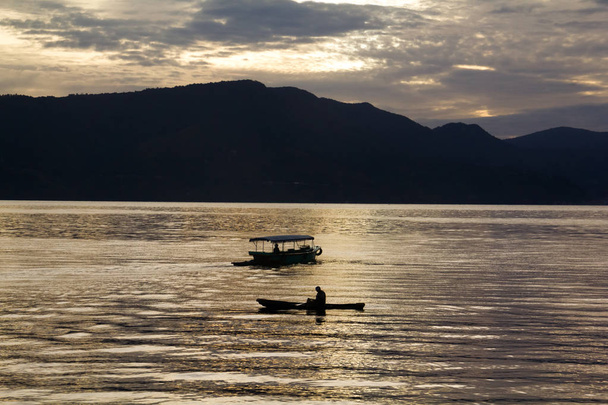 Zonsopgang met reflecties op Lake Toba, Samosir eiland, Indonesië. - Foto, afbeelding