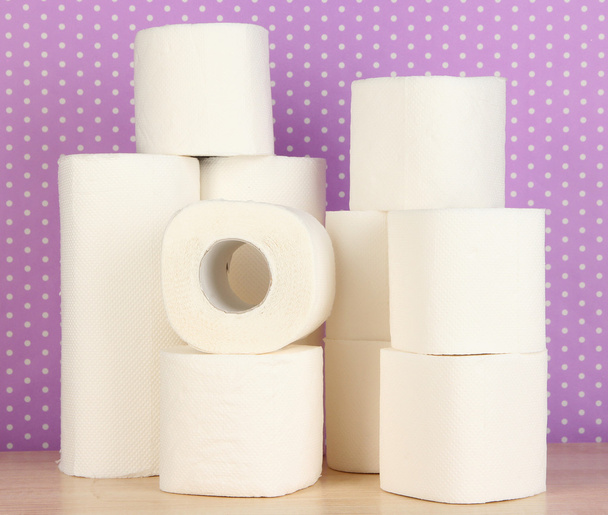 Rolls of toilet paper on purple with dots background - Фото, изображение