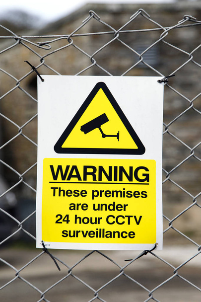Señal de advertencia con vigilancia CCTV 24 horas conectada a una valla perimetral en formato vertical
 - Foto, imagen