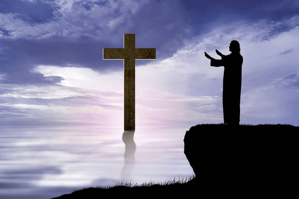 Silhouette des Jesus hebt die Hand und betet auf dem Hügel - Foto, Bild
