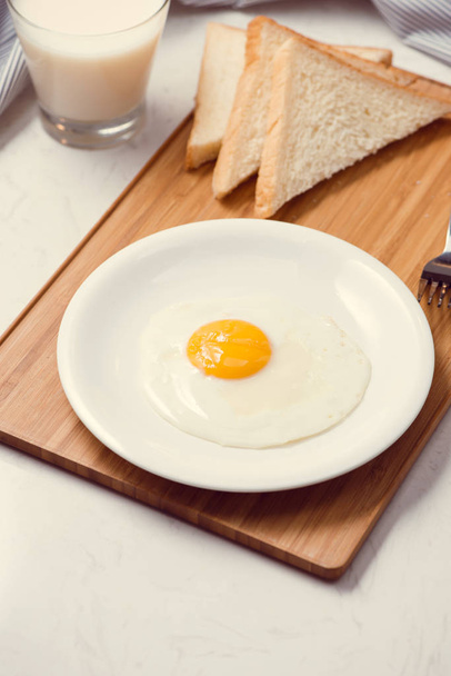 Смажені яйця з тостами та молоком на столі
 - Фото, зображення