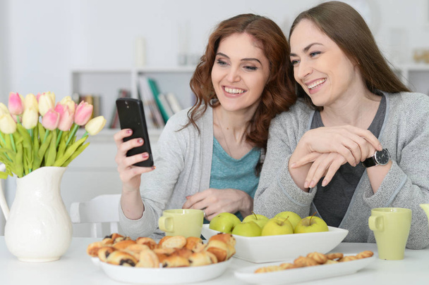 two female friends looking at smartphone - Foto, Bild
