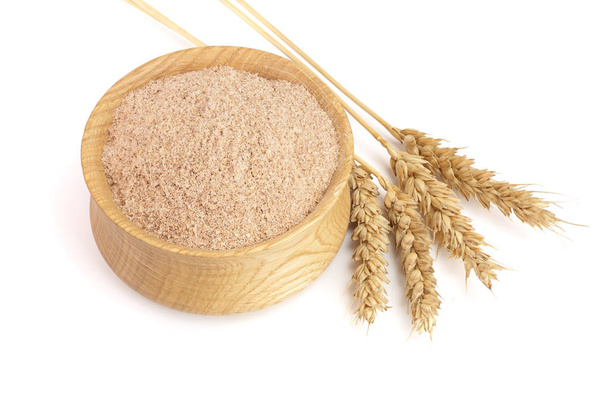 Pilha de farelo de trigo em tigela de madeira com orelhas isoladas em fundo branco
 - Foto, Imagem