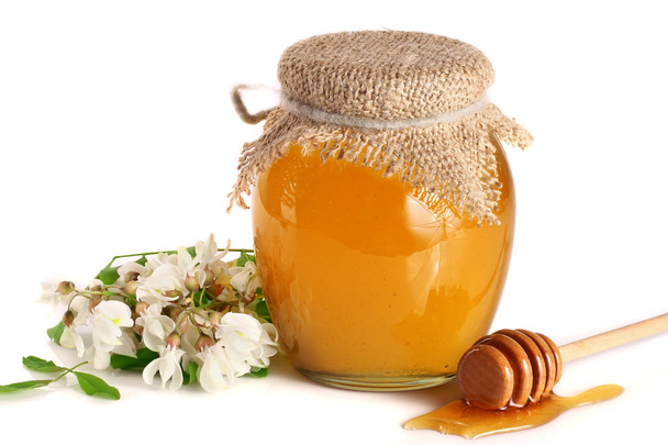 Pot met honing met acacia bloemen geïsoleerd op witte achtergrond - Foto, afbeelding
