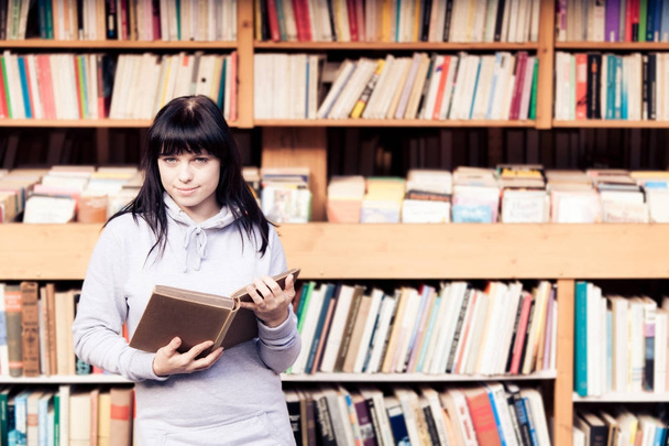 Jovem mulher olhando para livros em uma livraria
 - Foto, Imagem
