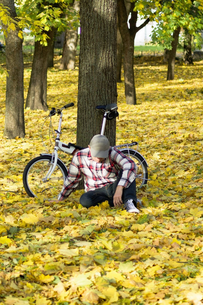 Senior and his bicycle in autumn park. - Fotoğraf, Görsel