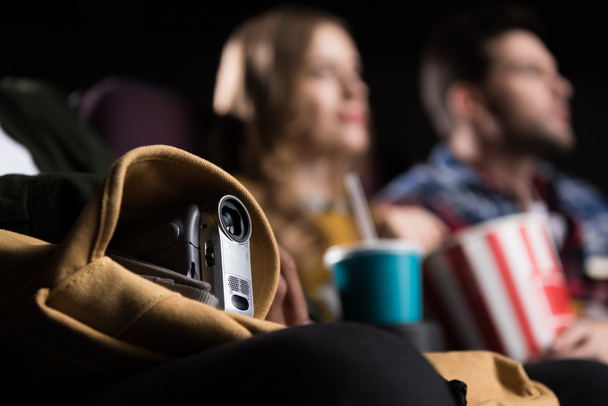 selective focus of people with video camera pirating in cinema - Photo, Image