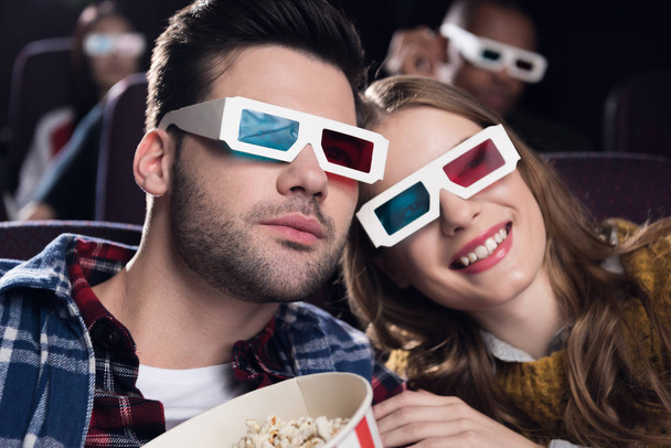 young couple in 3d glasses with popcorn watching movie in cinema - Fotografie, Obrázek