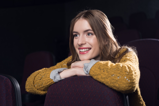 young cheerful girl watching film in movie theater - Photo, Image