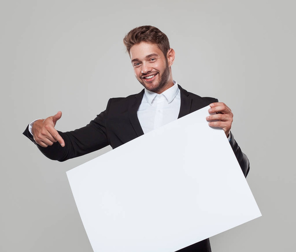 Man in suit pointing at white board - Photo, Image