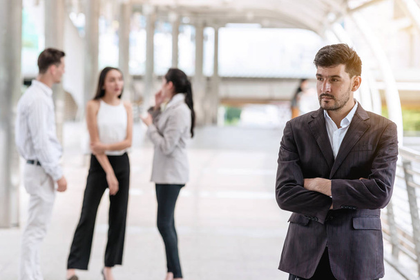 Confident young business team portrait concept. Handsome white male in smart casual dress portrait outdoor with his team in background, successful modern start up concept. - Фото, зображення