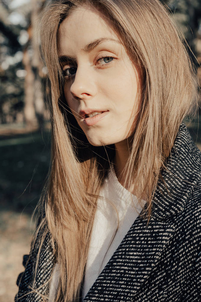Close up headshot of pretty blonde woman in coat outdoor - Zdjęcie, obraz