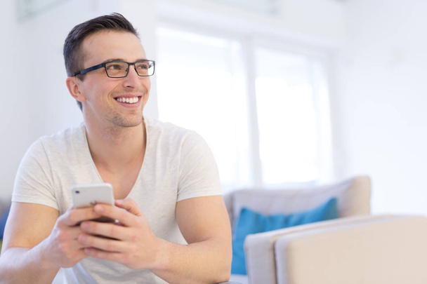 young man using a mobile phone  at home - Photo, Image