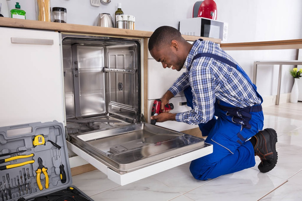 Repairman Fixing Dishwasher - Foto, immagini