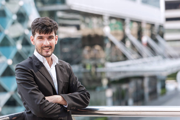 Confident young business man portrait concept. Handsome white male in black suit, black hair and beard taken outdoor with natural light, successful modern business man concept. - Fotografie, Obrázek
