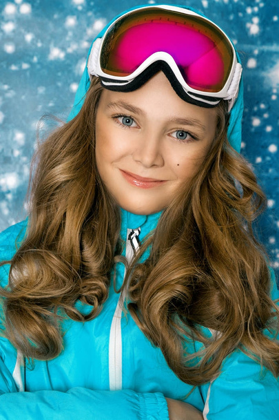 Cute, beautiful blonde young girl dressed in ski outfit and ski goggles - Foto, afbeelding