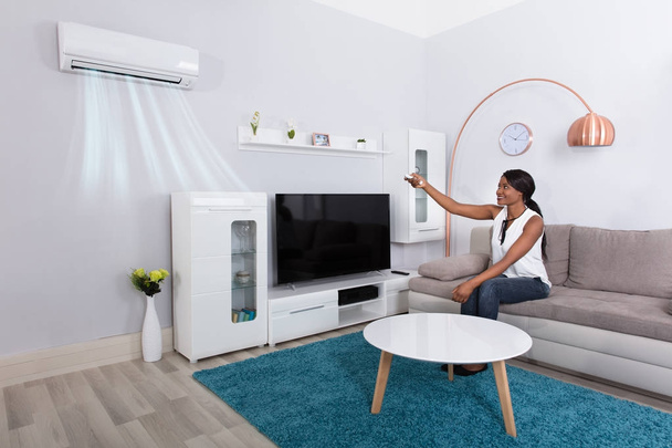 Woman Using Air Conditioner  - Foto, immagini