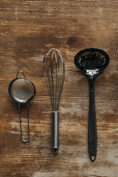 top view of metallic kitchen utensils on wooden table - 写真・画像