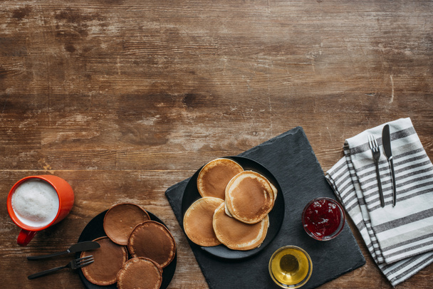 top view of freshly baked pancakes and coffee on wooden table - Photo, Image