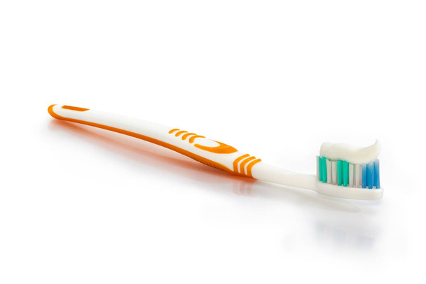 Cepillo de dientes con pasta de dientes en la superficie blanca
 - Foto, imagen