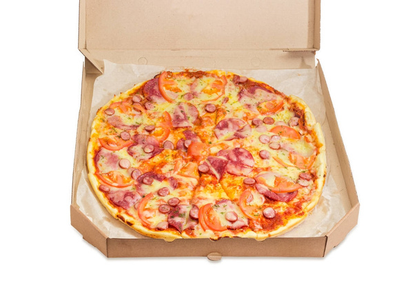 Πίτσα σερβίρεται σε ένα κουτί από χαρτόνι σε λευκό φόντο - Φωτογραφία, εικόνα