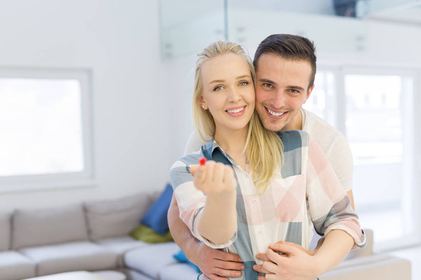couple showing small red house in hands - Foto, immagini
