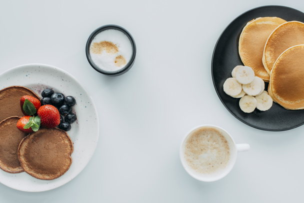 felülnézet ízletes reggeli két palacsinta és a kávé, a fehér asztal - Fotó, kép
