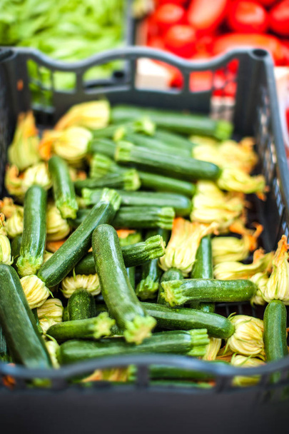 Fresh organic Zucchini with zucchini flowers at outdoor farmers  market. Healthy local food market concept - Foto, Imagen