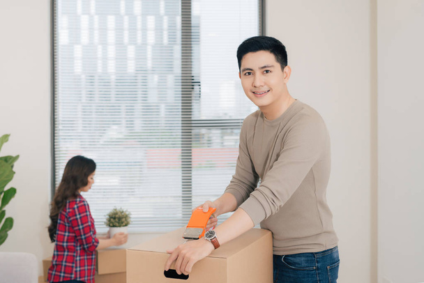 Smiling couple with big cardboard boxes moving to new place - Photo, Image