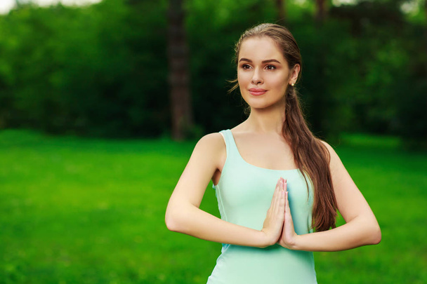 Belle jeune femme faisant de l'exercice de yoga en plein air - Photo, image