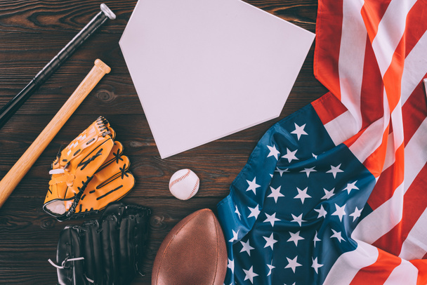 american flag and sport equipment with blank paper on wooden table - Foto, Imagen