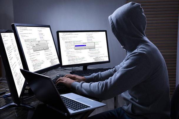 Hacker Using Multiple Computers - Foto, afbeelding