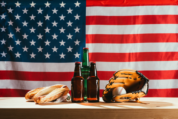 Detailní zobrazení lahve od piva, hot dogy, kožené rukavice a baseballový míč na dřevěný stůl s námi označit za - Fotografie, Obrázek