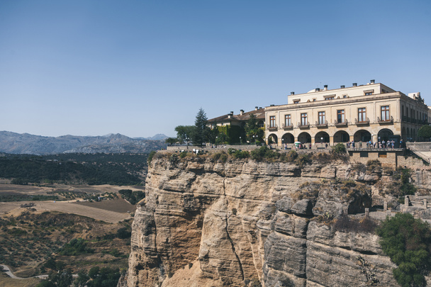 γραφική θέα του κτηρίου στον βράχο εναντίον τοπίο στα βουνά, Ronda, Ισπανία - Φωτογραφία, εικόνα
